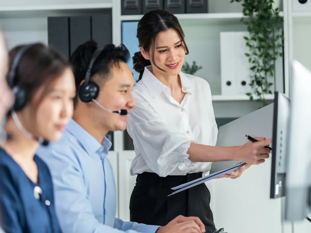 Equipe de atendimento com fones de ouvido trabalhando no computador