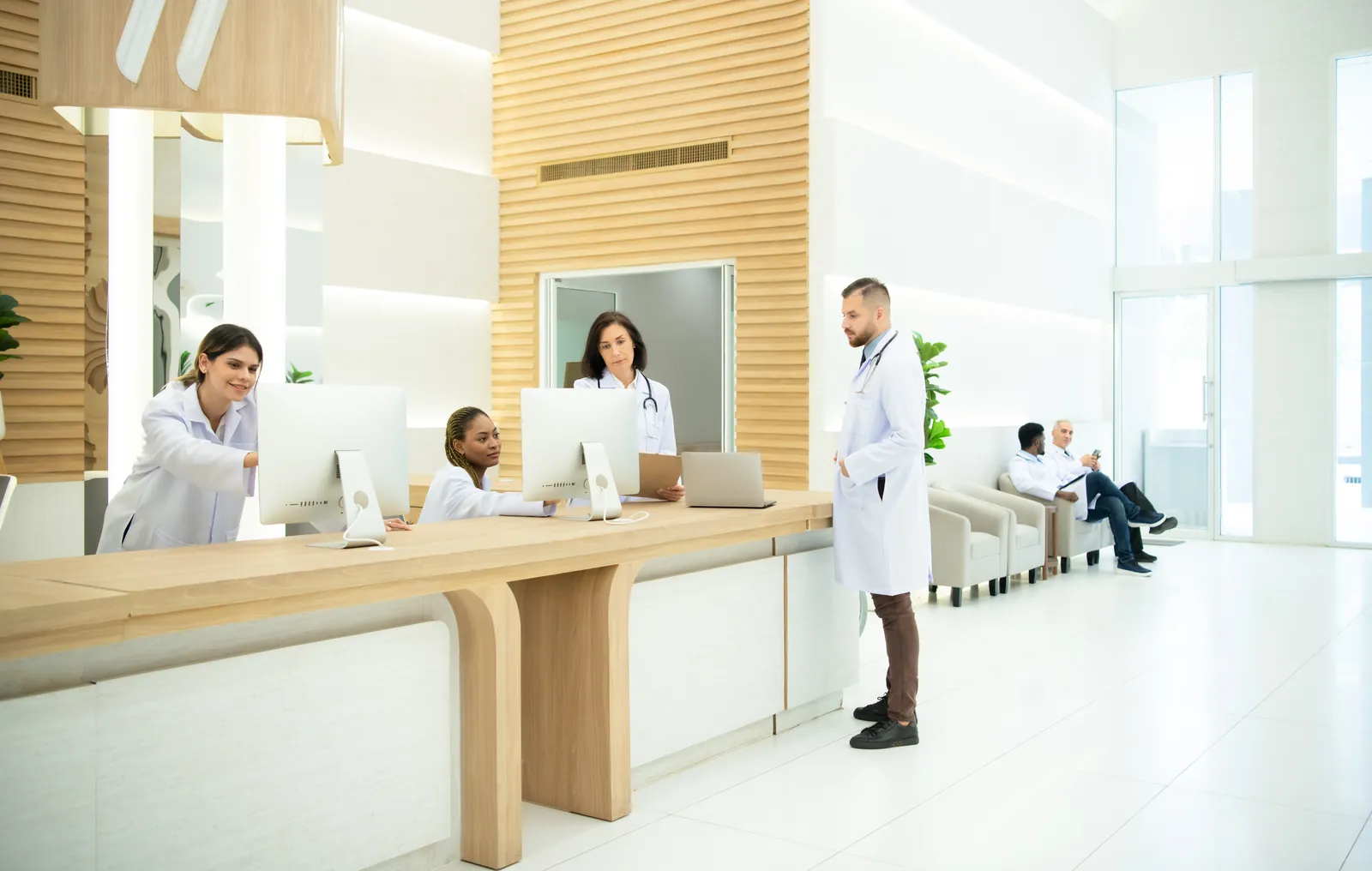 Recepção de clínica médica com médicos e equipe atendendo