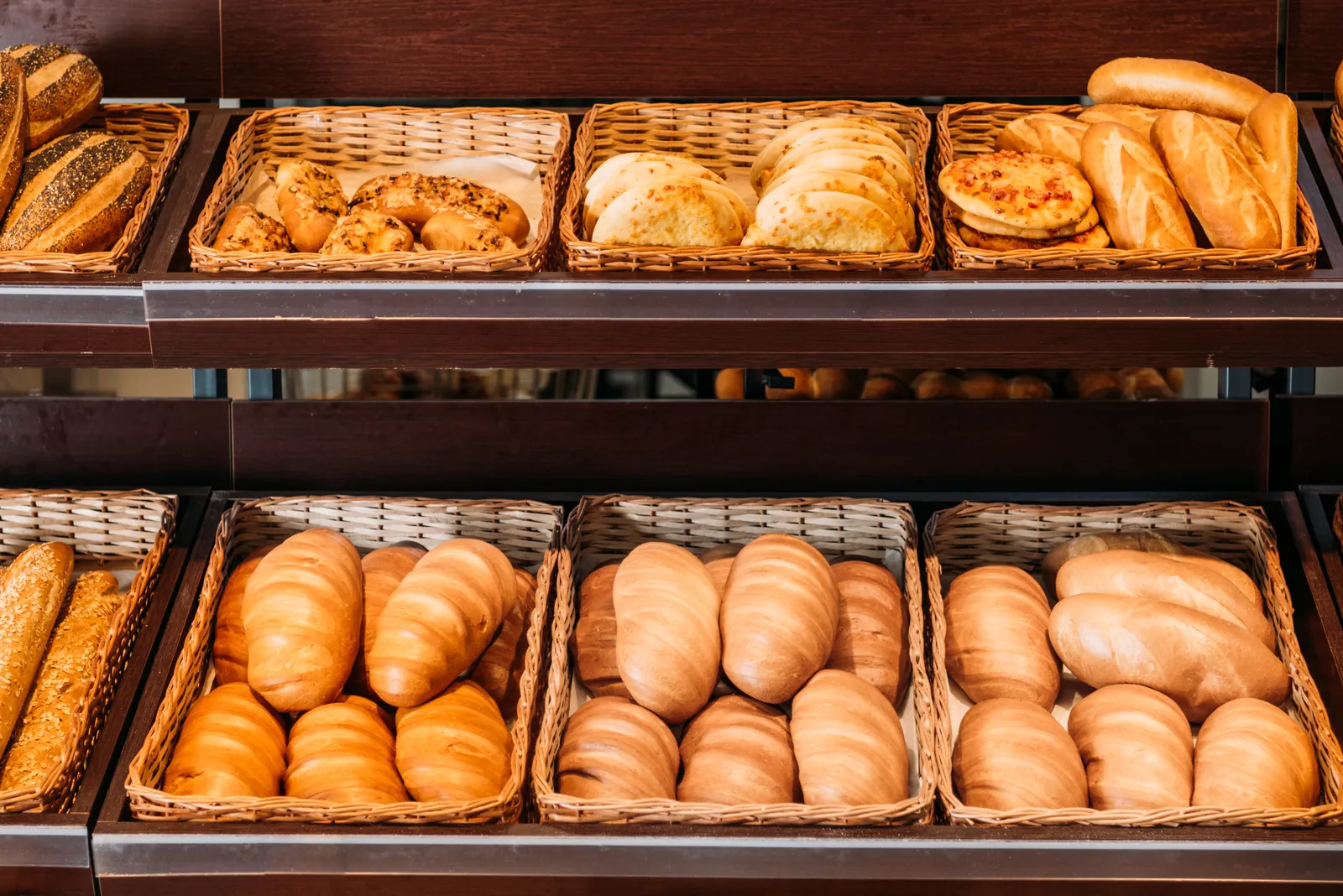 Cestas de pão francês e pães doces na prateleira de uma padaria em São Paulo